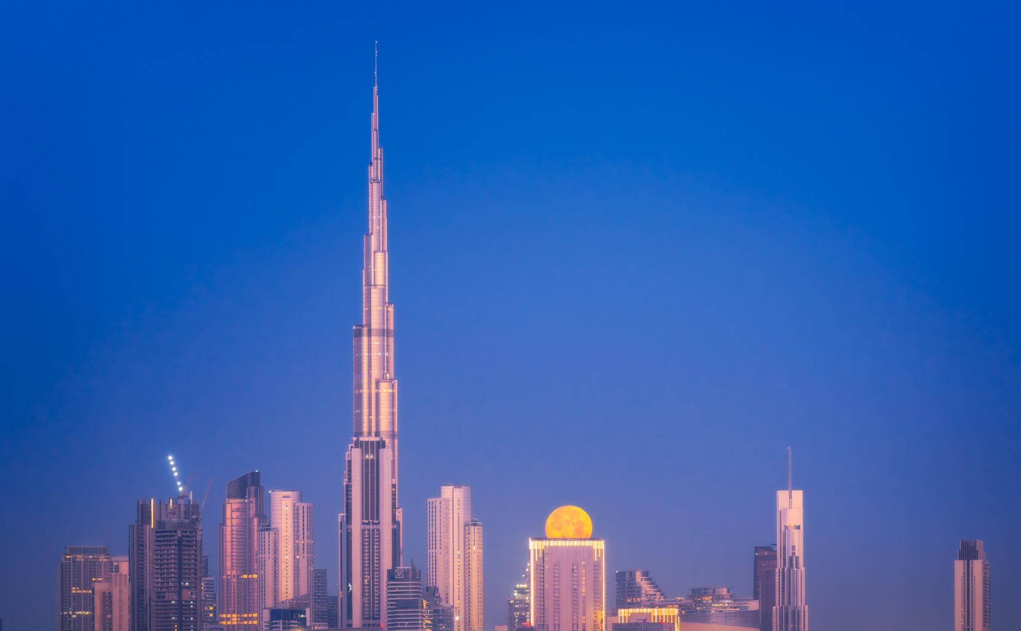 Dubai Skyline at Night with a Hidden Full Moon by Nico Trinkhaus