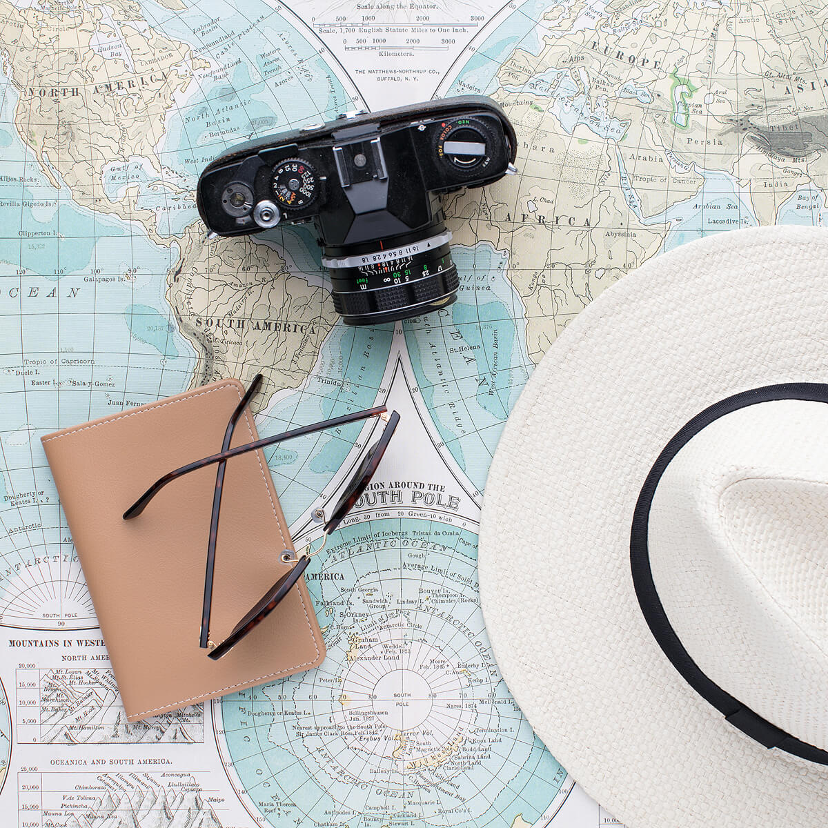 Photographer's camera with a sun hat and map of the world