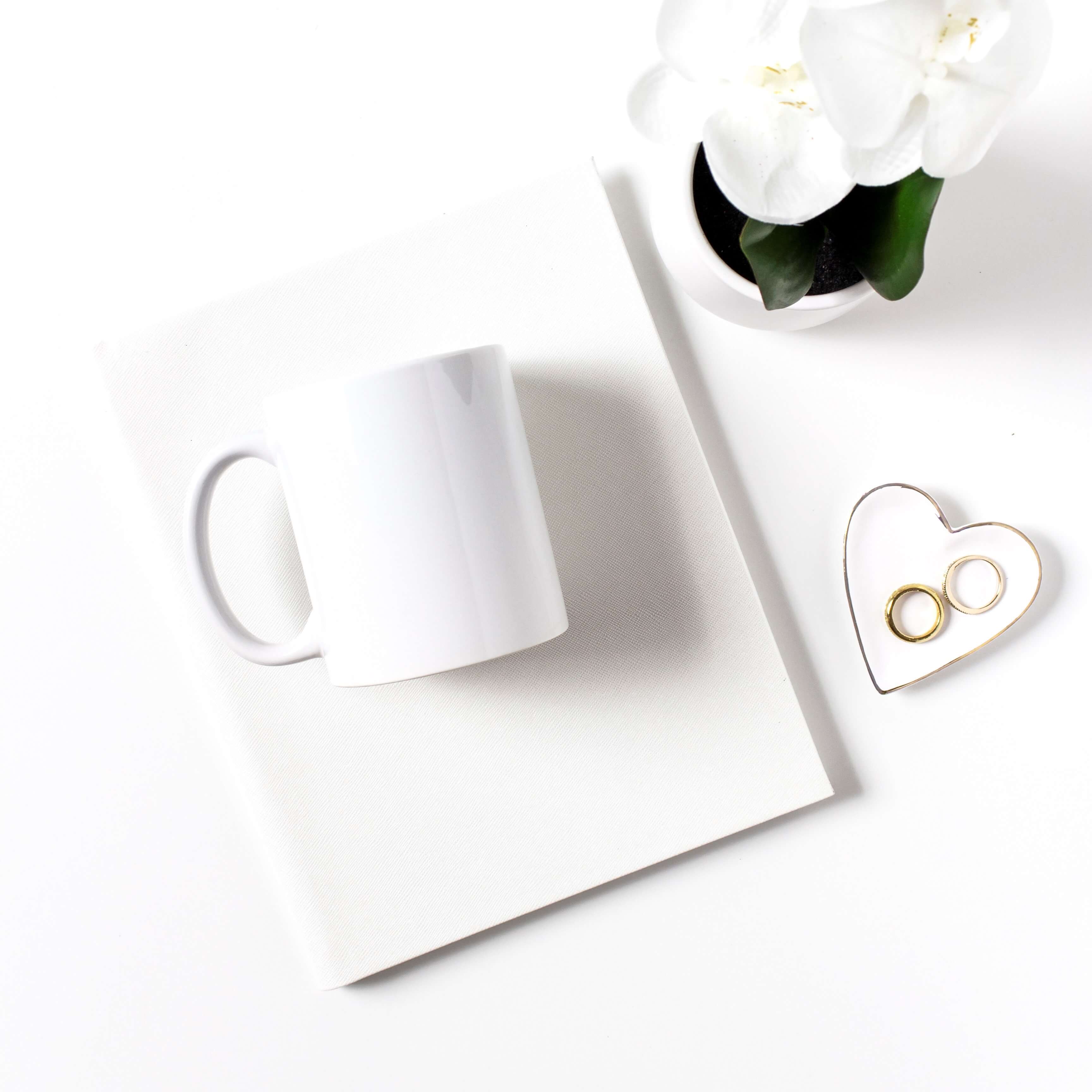 White mug next to white flowers