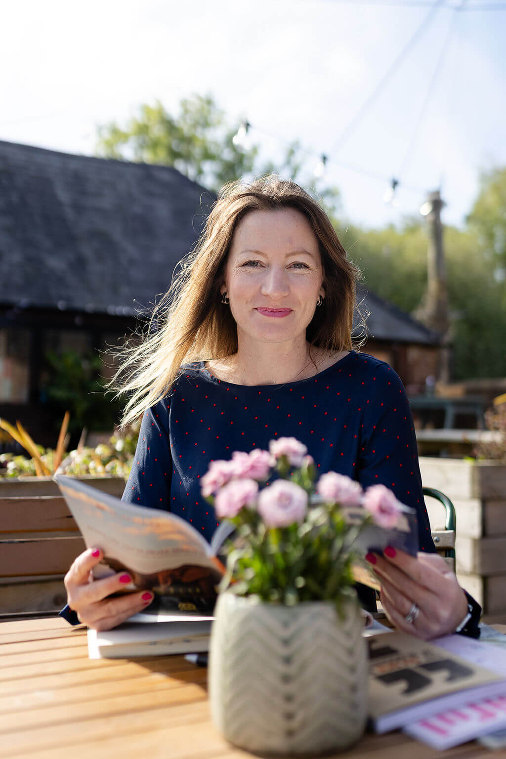 Zoe Hiljemark reading a magazine with flowers in the foreground
