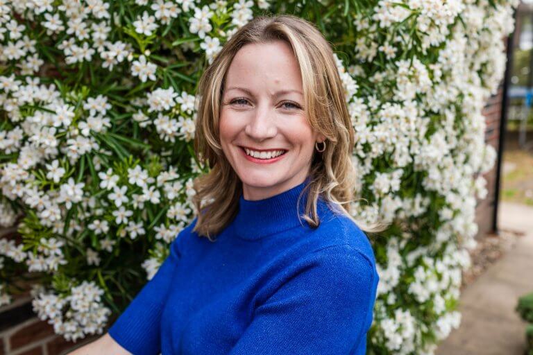 Zoe Hiljemark smiling in front of white flowers