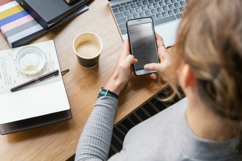 Woman at desk holding phone