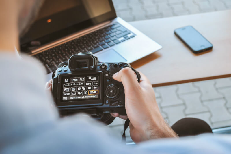 Professional photographeradjusting the camera settings